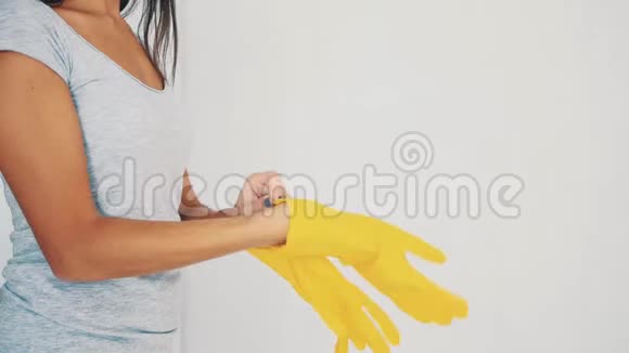 女性戴着黄色橡胶手套完全白色背景作物复制空间快关门4K视频的预览图