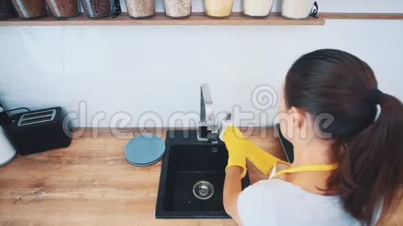 女人正在厨房的水槽里用海绵洗碗快关门上景4K视频的预览图
