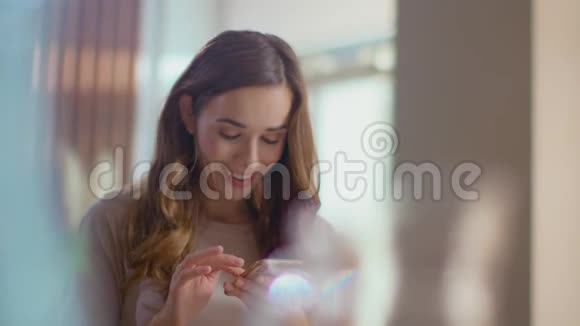 女人在家里用手机接收信息在看手机的女孩视频的预览图