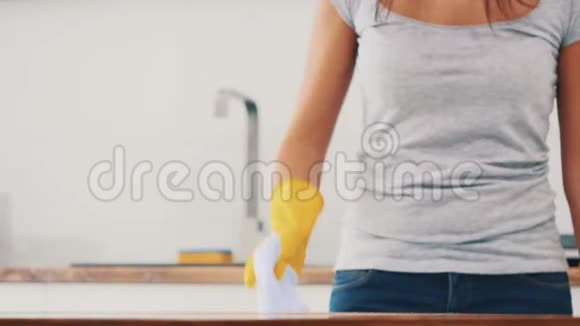 戴着黄色橡胶手套的女人正在厨房用除脂剂喷雾剂和除尘器清洗烹饪面板作物复制空间视频的预览图
