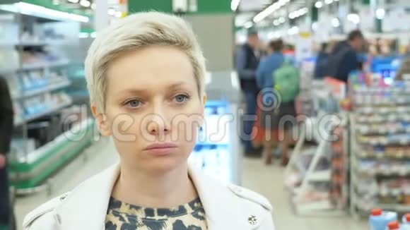 超市里一个疲惫的女人的肖像特写视频的预览图