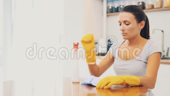 戴黄色橡胶手套的女人厌倦了用除脂剂喷雾清洗厨房快关门4K视频的预览图