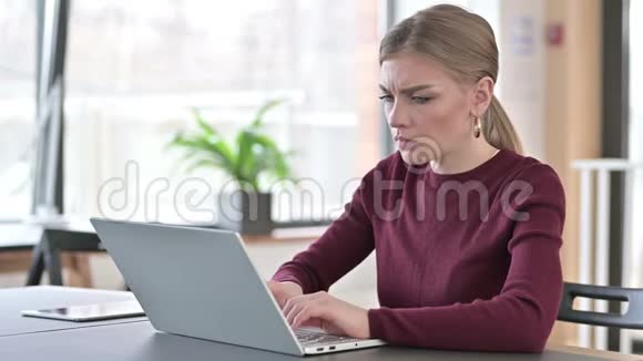 办公室使用笔记本电脑头痛的年轻女性视频的预览图