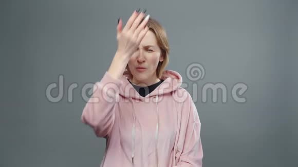 穿着粉色运动衫脸型手势的疯女人视频视频的预览图