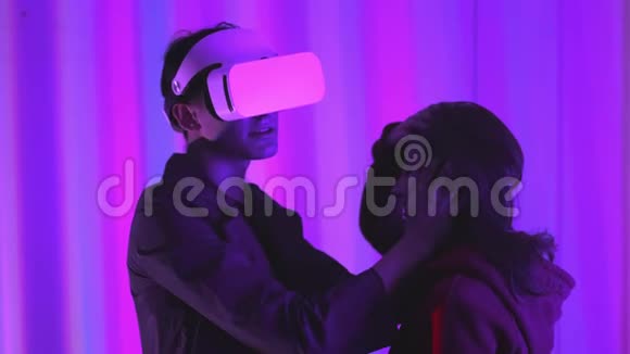 年轻人和女孩是虚拟现实眼镜的职业玩家沉浸在平行的现实中创造视频的预览图