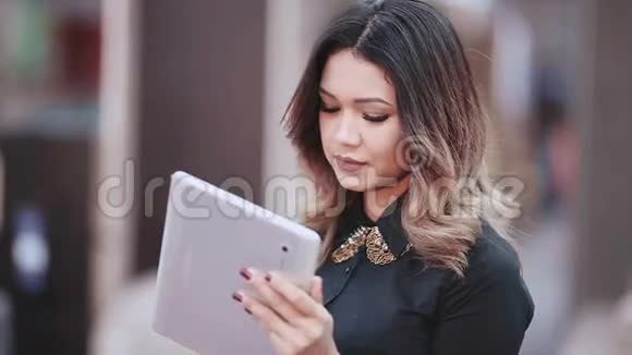 平板电脑商务女性使用数字平板电脑PC穿商务衬衫的漂亮混血女人视频的预览图