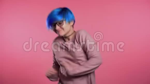 美丽的女人时髦的蓝色头发跳舞彩色粉红色工作室背景视频的预览图