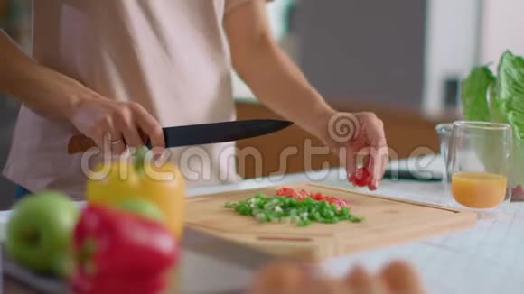 女人在木板上切蔬菜微笑的女士在厨房做沙拉视频的预览图