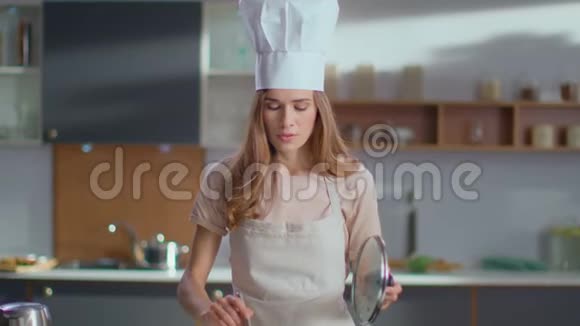 厨师在炉子上煮汤在家准备晚餐的女人视频的预览图