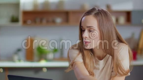 女商人在厨房里用笔记本电脑女士慢吞吞地吃玉米片视频的预览图