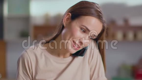 女人在家里用智能手机说话家庭主妇切蔬菜沙拉视频的预览图