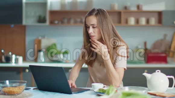 女商人下班后在厨房关闭手提电脑女士从家里出去视频的预览图