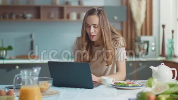 女人在笔记本电脑上和朋友在线聊天女士在家里用网络摄像机打手势视频的预览图