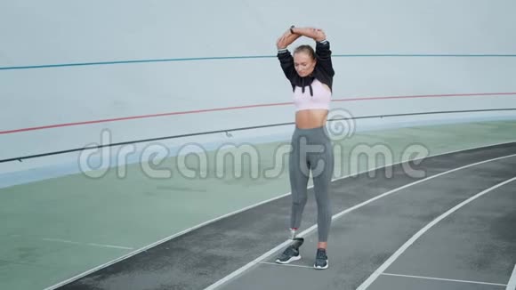 残疾女运动员在体育场伸展手臂女孩在户外热身视频的预览图