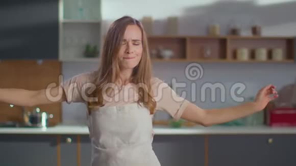 在厨房跳舞的女人一位女士手拿胡须在厨房做手势视频的预览图