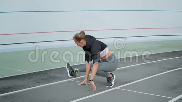 残疾妇女在跑道上伸展双腿准备户外运动的女士视频的预览图