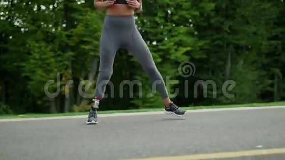 残疾妇女在道路上侧跳女孩在柏油路上跳跃视频的预览图