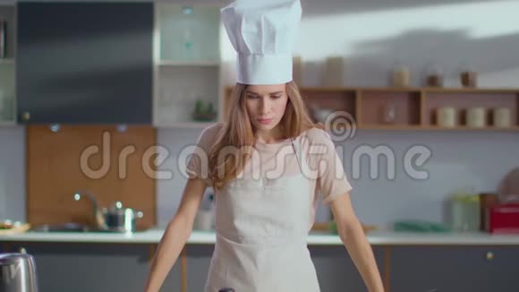 厨师在厨房用手交叉勺子女人对着镜头微笑视频的预览图