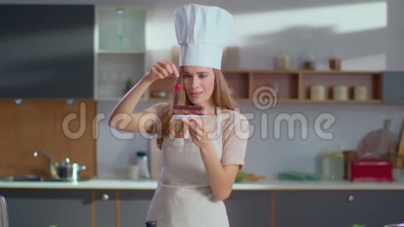 面包师在厨房用樱桃装饰蛋糕厨师女士完成甜点视频的预览图