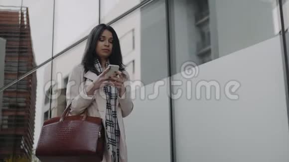 沮丧的女商人在户外使用手机愤怒的女人走在街上视频的预览图