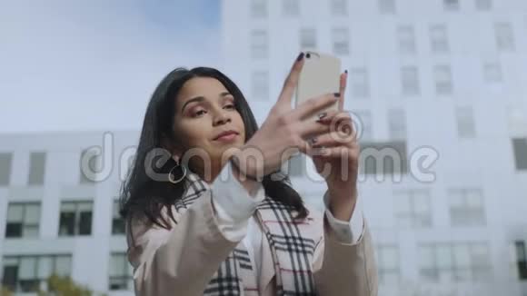 女商人在街上用智能手机自拍使用手机的女孩视频的预览图