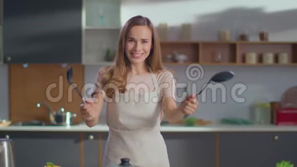 女人手里拿着勺子在厨房里在厨房里看摄像机的女人视频的预览图