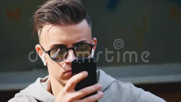 闭上男人脸他在用手机戴着墨镜复制空间4K视频的预览图
