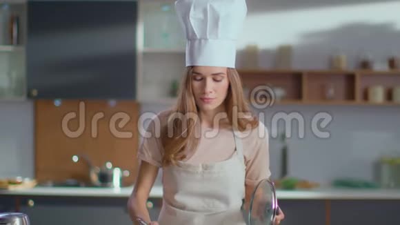 厨师在厨房品尝汤穿制服的女人在炉子上煮汤视频的预览图