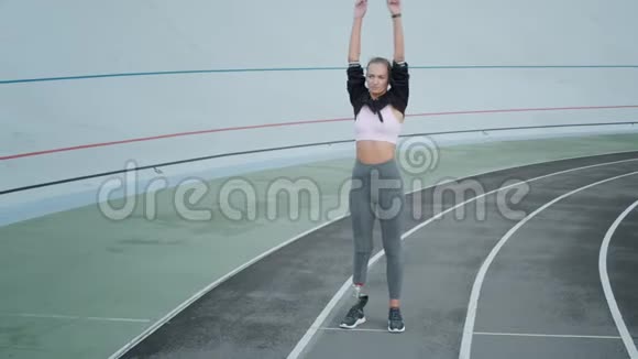 带有人工肢体变暖的慢跑者女子在体育场伸手视频的预览图
