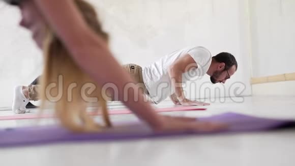 灵活的健身女性练习瑜伽站在面向狗的姿势下视频的预览图