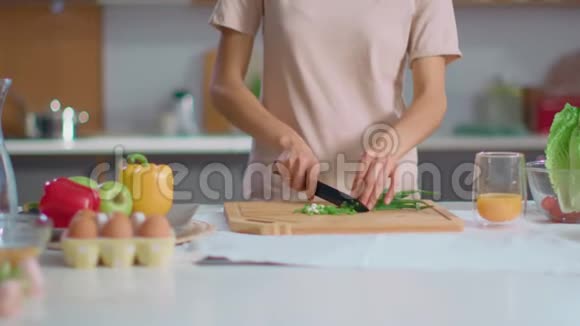 女人在厨房的木板上切洋葱家庭主妇准备沙拉视频的预览图