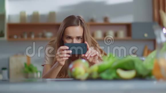 美食博主在厨房蔬菜手机拍照视频的预览图