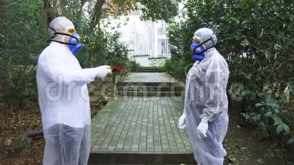 公园里穿着防化服和防毒面具的男人和女人那人给了一朵花视频的预览图