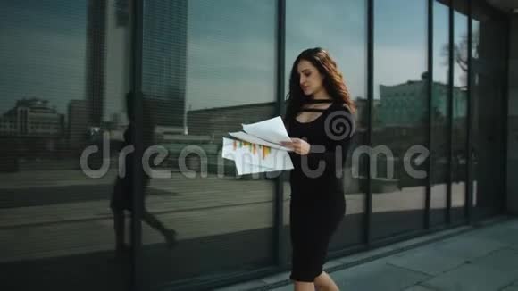 女人手里拿着文件微笑在街上扔纸的女人视频的预览图