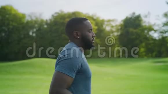 疲惫的男运动员在公园里跑步在绿色地区培训非洲裔男子视频的预览图