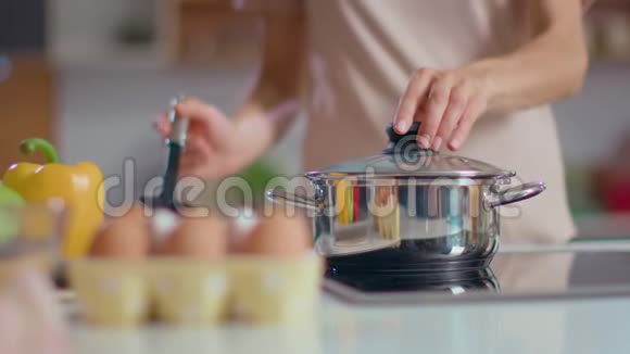 厨师女人在炉子上煮汤满意的家庭主妇用勺子品尝美食视频的预览图