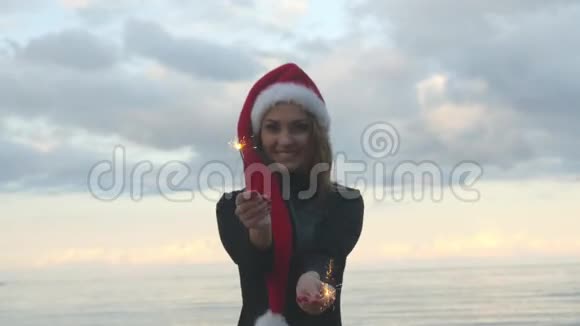 戴着圣诞帽的年轻女人拿着火花视频的预览图
