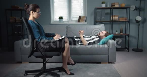 沮丧的男人躺在心理学家办公室的沙发上视频的预览图