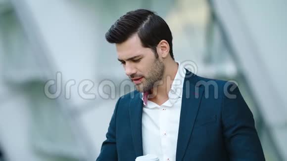 肖像男站着喝咖啡和打电话喝酒的人带走咖啡视频的预览图