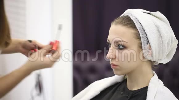 化妆师在年轻女孩的眼睛上化妆视频的预览图
