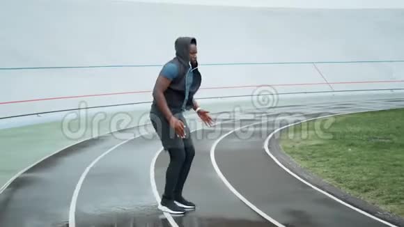 跑步者在体育场原地跳跃有氧运动前的慢跑热身运动视频的预览图