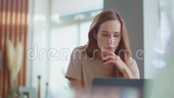 微笑的女商人在家里办公室用笔记本电脑打字女孩在笔记本电脑上聊天视频的预览图
