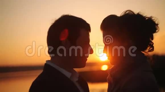 日落时分在海滩上接吻的快乐情侣视频的预览图