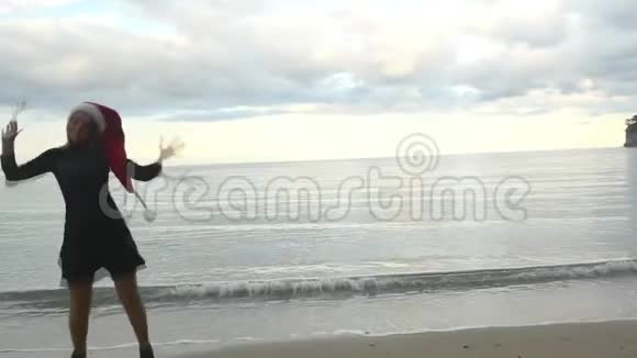 戴着圣诞帽的滑稽女人在海边跳跃视频的预览图