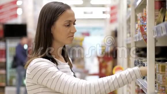 年轻女子在超市偷罐头食品视频的预览图