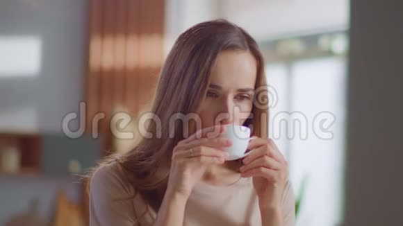 满意的女人在厨房喝茶女士在家喝杯咖啡视频的预览图