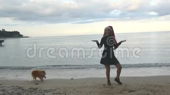 戴着圣诞帽的滑稽女人在海边跳舞视频的预览图