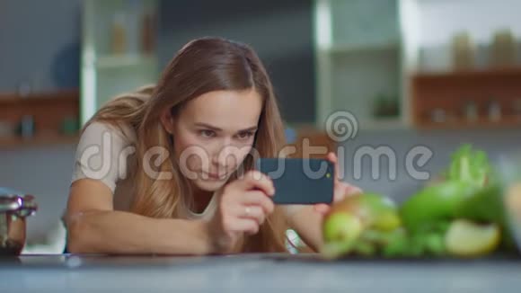 厨房水果组合智能手机拍照的女人视频的预览图