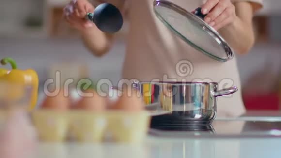 无法辨认的女人在厨房煮汤家庭主妇用勺子搅拌汤视频的预览图