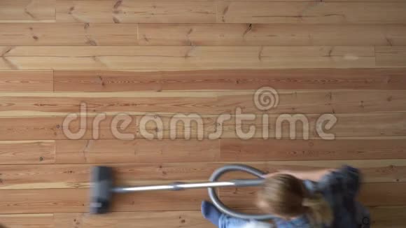 打扫房子一个女人在公寓里吸木地板俯视视频的预览图